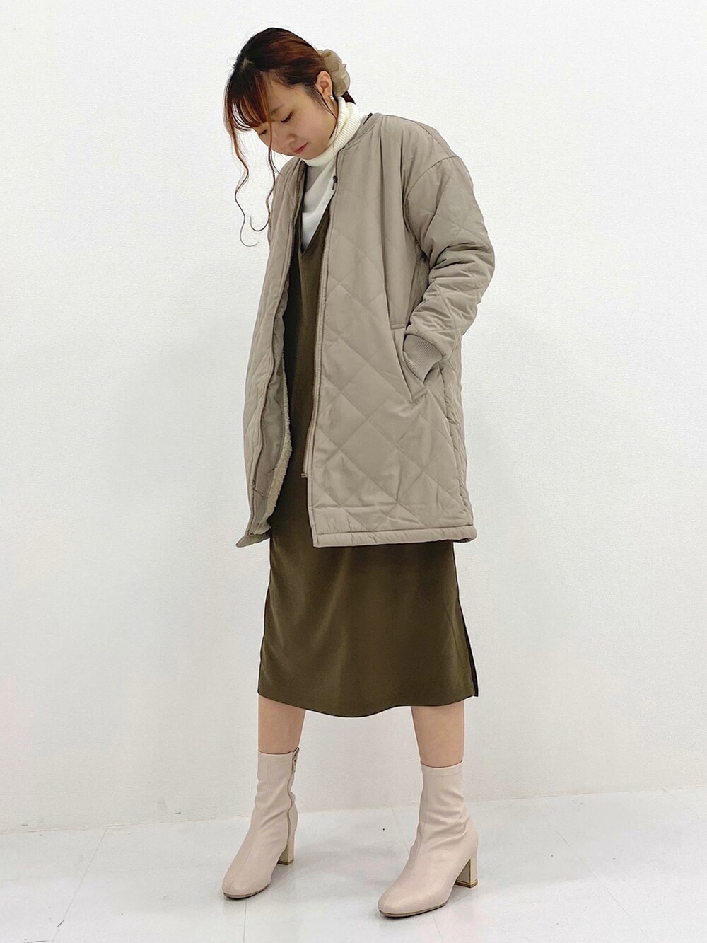 ブラウン系のジャンパースカート、ベージュ系のブルゾン、ホワイト系のニット/セーターを着用したレディースの秋コーディネートの2枚目の写真