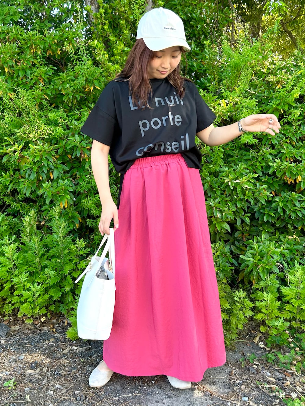 ブラック系のTシャツ/カットソー、レッド系のスカート、ホワイト系のトートバッグを着用したレディースの夏コーディネートの2枚目の写真