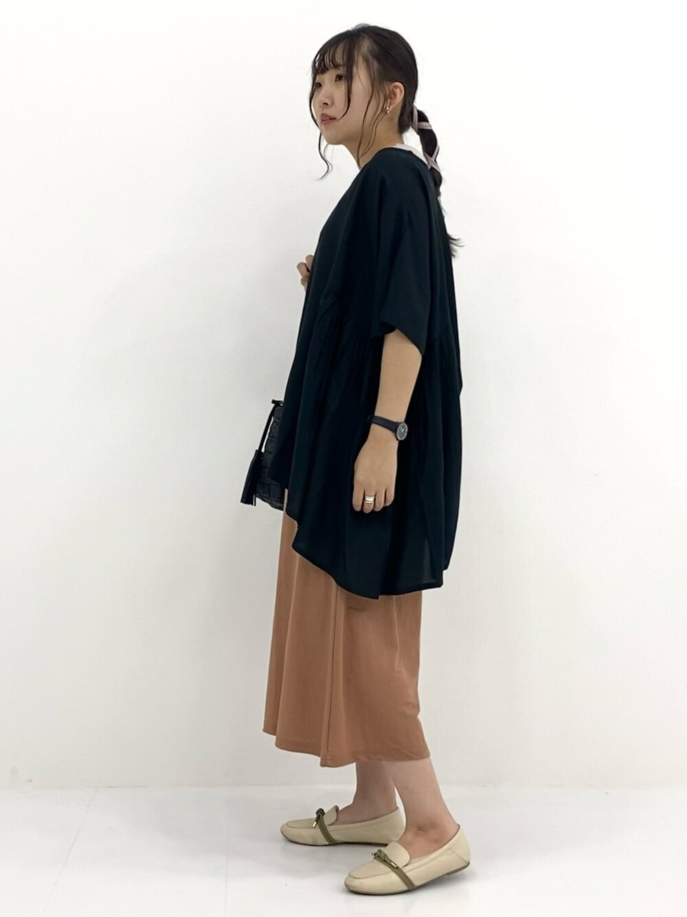 オレンジ系のパンツ、グリーン系のシャツ/ブラウスを着用したレディースの秋コーディネートの2枚目の写真