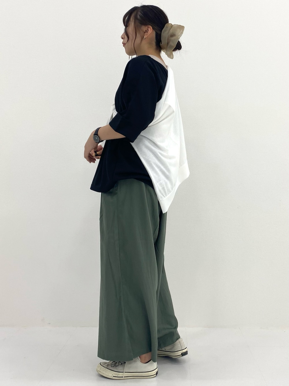 ブラック系のトップス、ブルー系のパンツ、ホワイト系のパーカーを着用したレディースの秋コーディネートの3枚目の写真