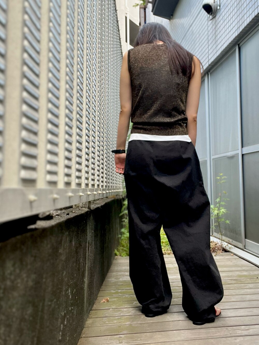 ブラック系のパンツ、ブラック系のタンクトップ、オレンジ系のシャツ/ブラウスを着用したレディースの夏コーディネートの2枚目の写真