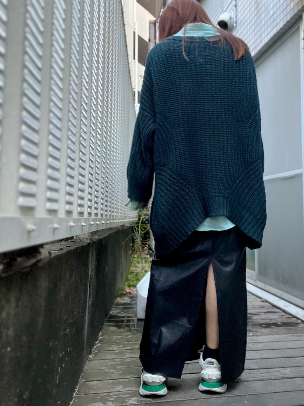 ブラック系のスカート、ベージュ系のスニーカー、グリーン系のシャツ/ブラウスを着用したレディースの春コーディネートの2枚目の写真