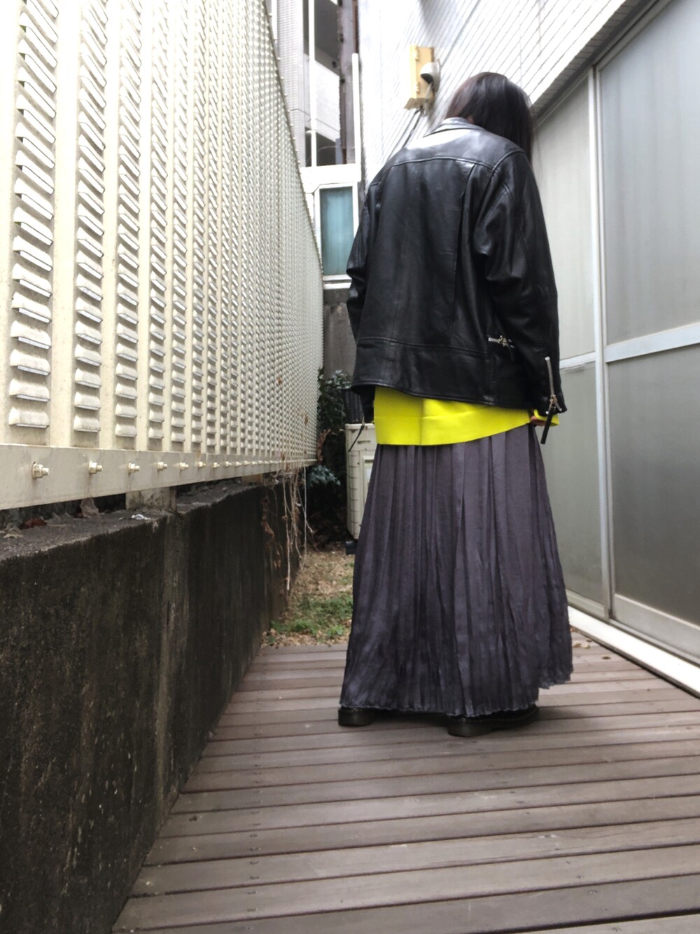 ブラック系のドレスシューズ、グレー系のスカート、イエロー系のカーディガン/ボレロを着用したレディースの春コーディネートの2枚目の写真