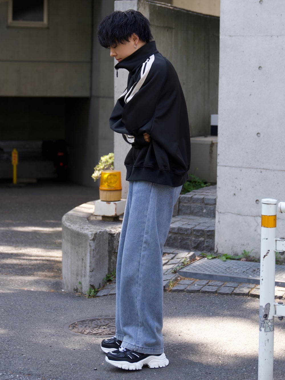 ブラック系のジャージ、ホワイト系のタンクトップ、ブルー系のデニムパンツを着用したメンズの春コーディネートの4枚目の写真