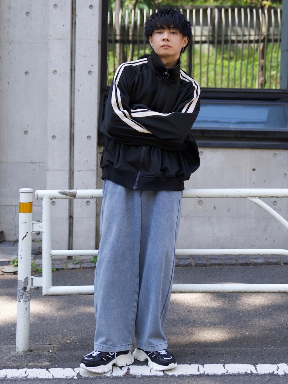 ブラック系のジャージ、ホワイト系のタンクトップ、ブルー系のデニムパンツを着用したメンズの春コーディネートの3枚目の写真