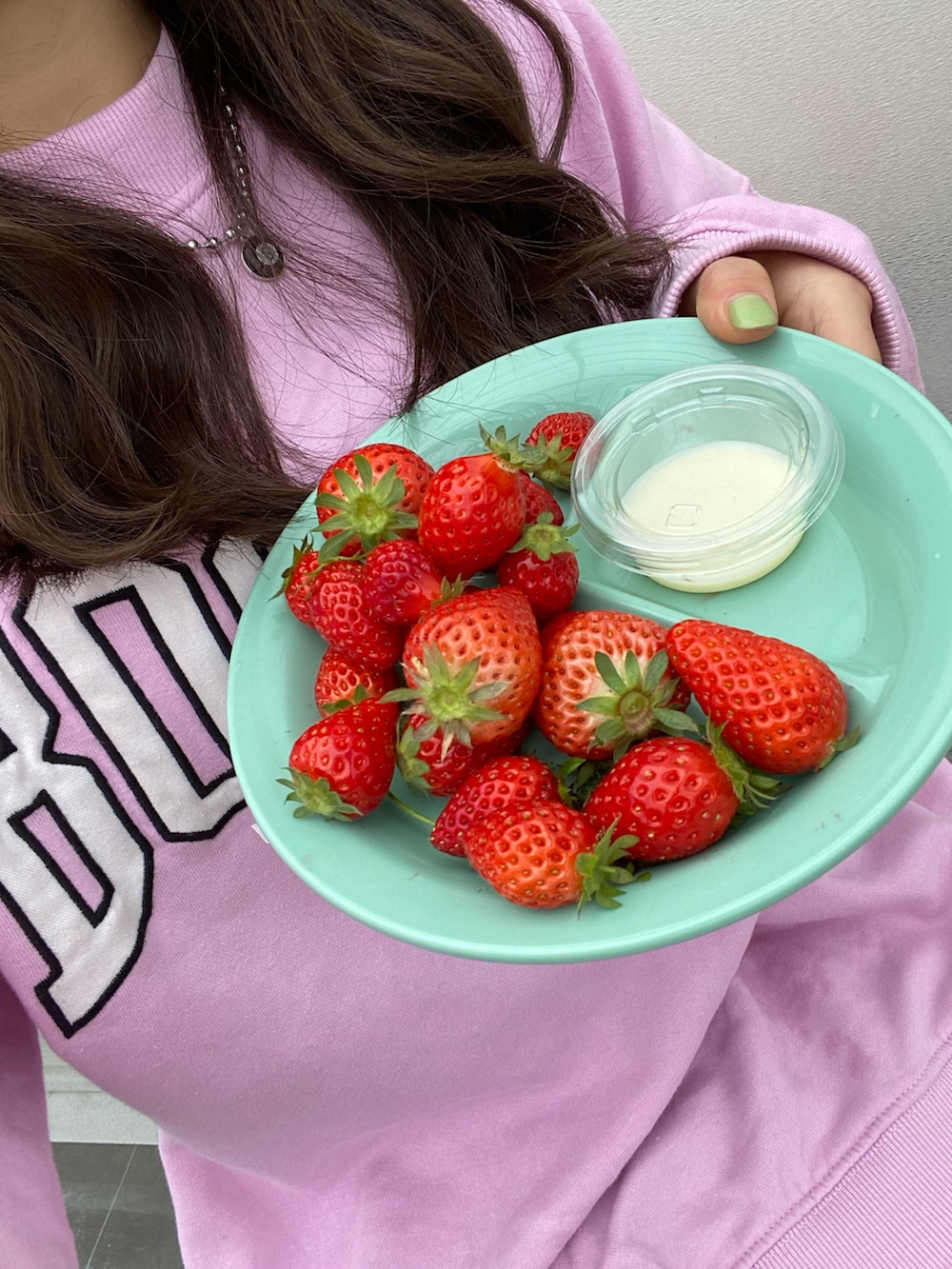 ピンク系のスウェット、ブルー系のデニムスカート、ブラック系のブーツを着用したレディースの春コーディネートの2枚目の写真