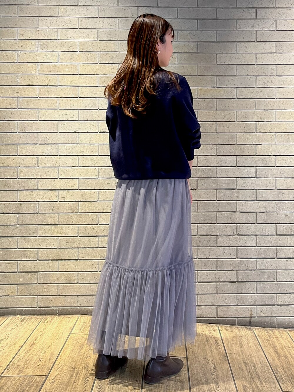 ブルー系のニット/セーター、グレー系のスカートを着用したレディースの冬コーディネートの2枚目の写真
