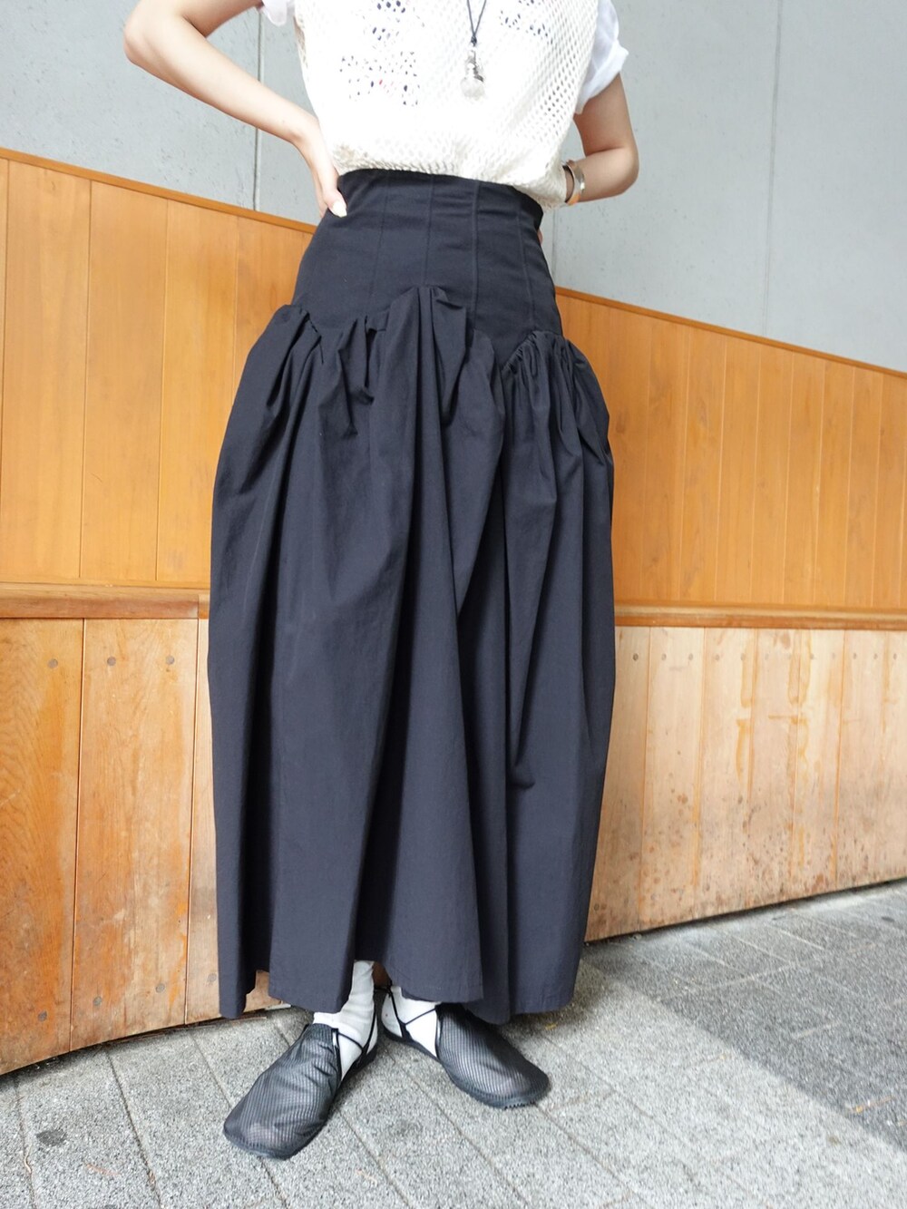 ブラック系のスカート、ベージュ系のTシャツ/カットソー、ブラック系のサンダルを着用したレディースの夏コーディネートの4枚目の写真