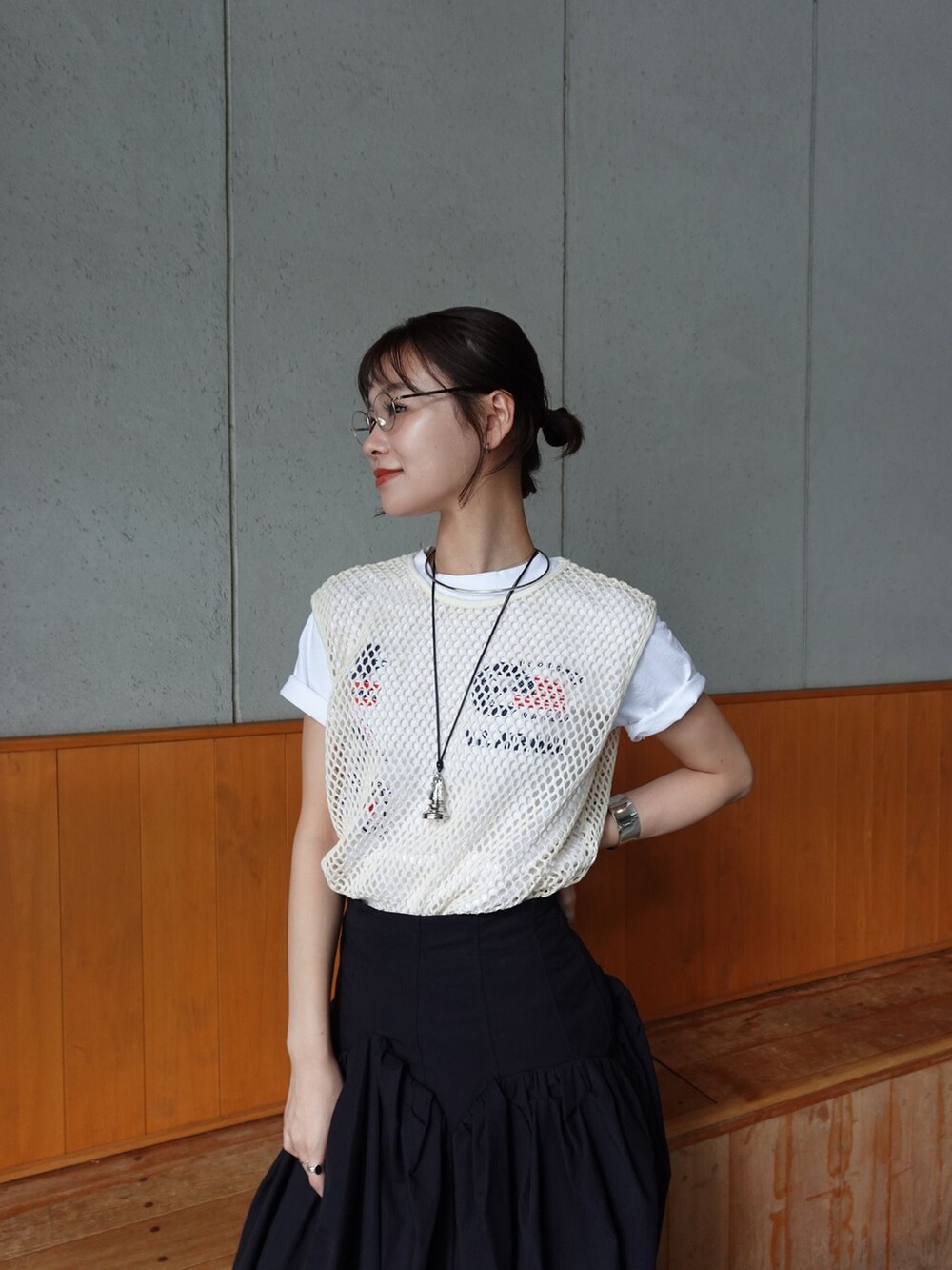 ブラック系のスカート、ベージュ系のTシャツ/カットソー、ブラック系のサンダルを着用したレディースの夏コーディネートの2枚目の写真