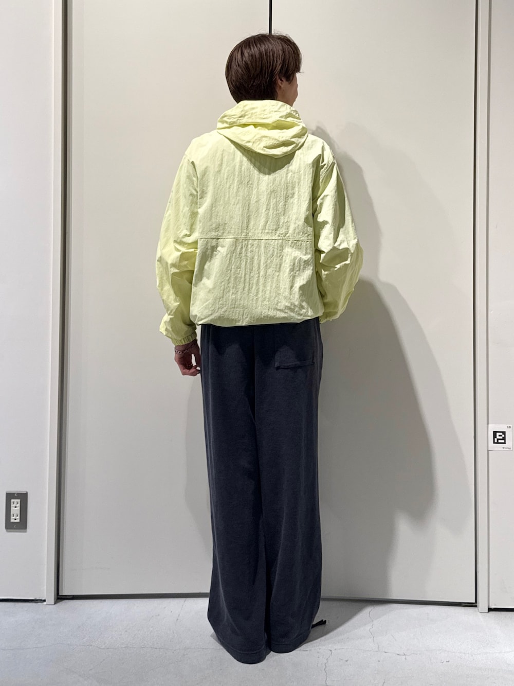 イエロー系のマウンテンパーカー、ブラック系のスウェットパンツを着用したメンズの春コーディネートの2枚目の写真