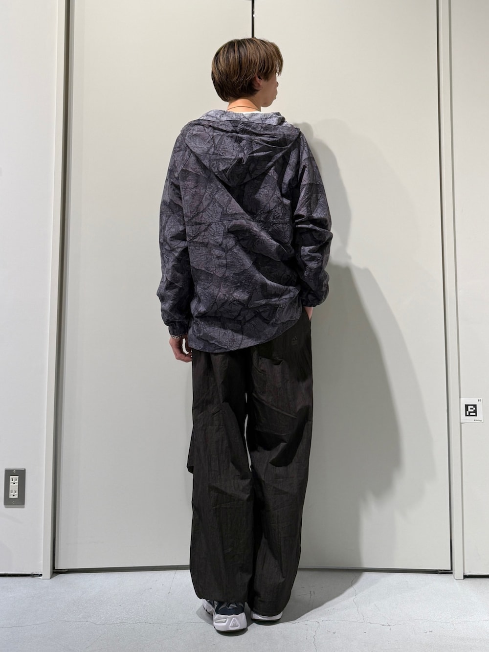 ブラック系のナイロンジャケット、グレー系のその他パンツを着用したメンズの春コーディネートの2枚目の写真