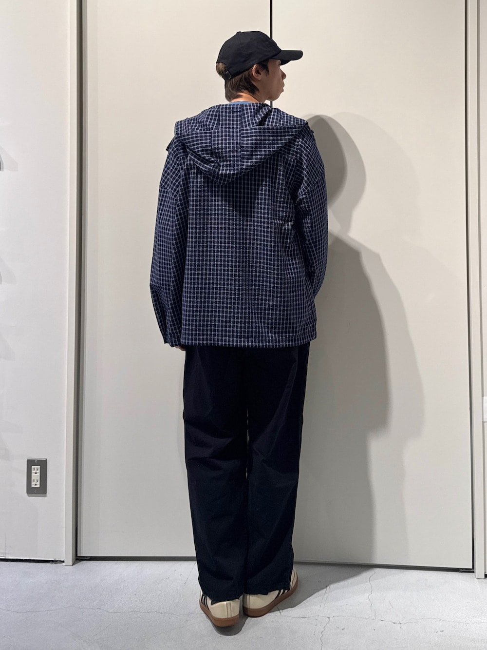 ブルー系のパーカー、ブルー系のニット/セーター、ブラック系のカーゴパンツを着用したメンズの春コーディネートの2枚目の写真