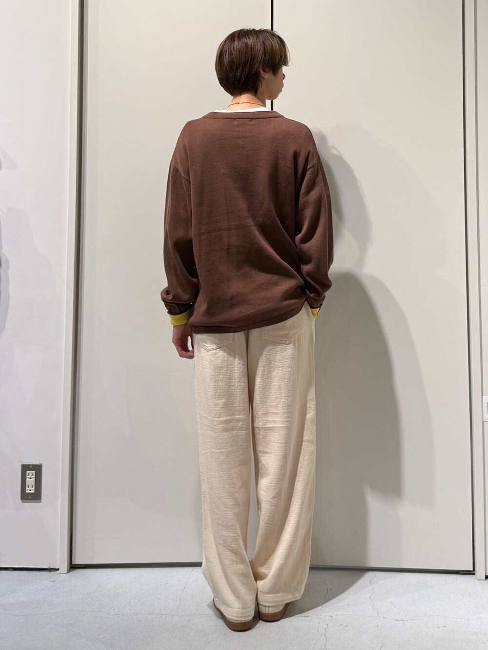 ブラウン系のニット/セーター、ホワイト系のその他パンツを着用したメンズの春コーディネートの2枚目の写真