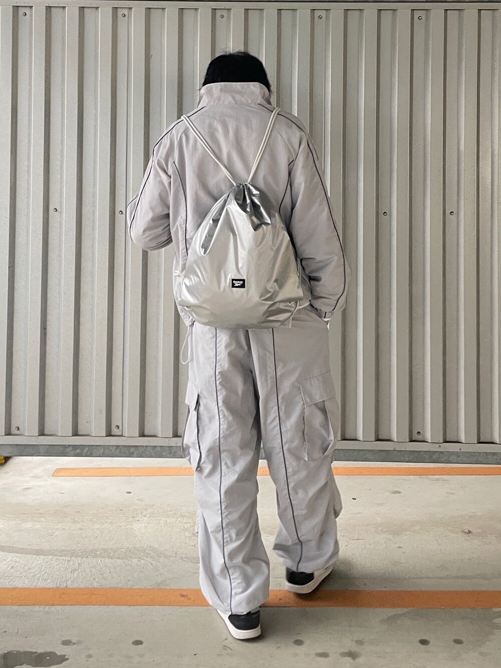 グレー系のカーゴパンツ、グレー系のナイロンジャケット、ホワイト系のスウェットを着用したメンズの春コーディネートの2枚目の写真