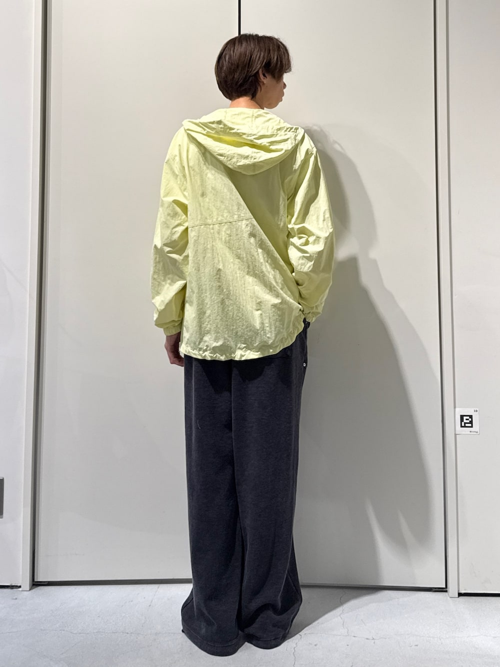 イエロー系のマウンテンパーカー、ブラック系のスウェットパンツを着用したメンズの春コーディネートの2枚目の写真