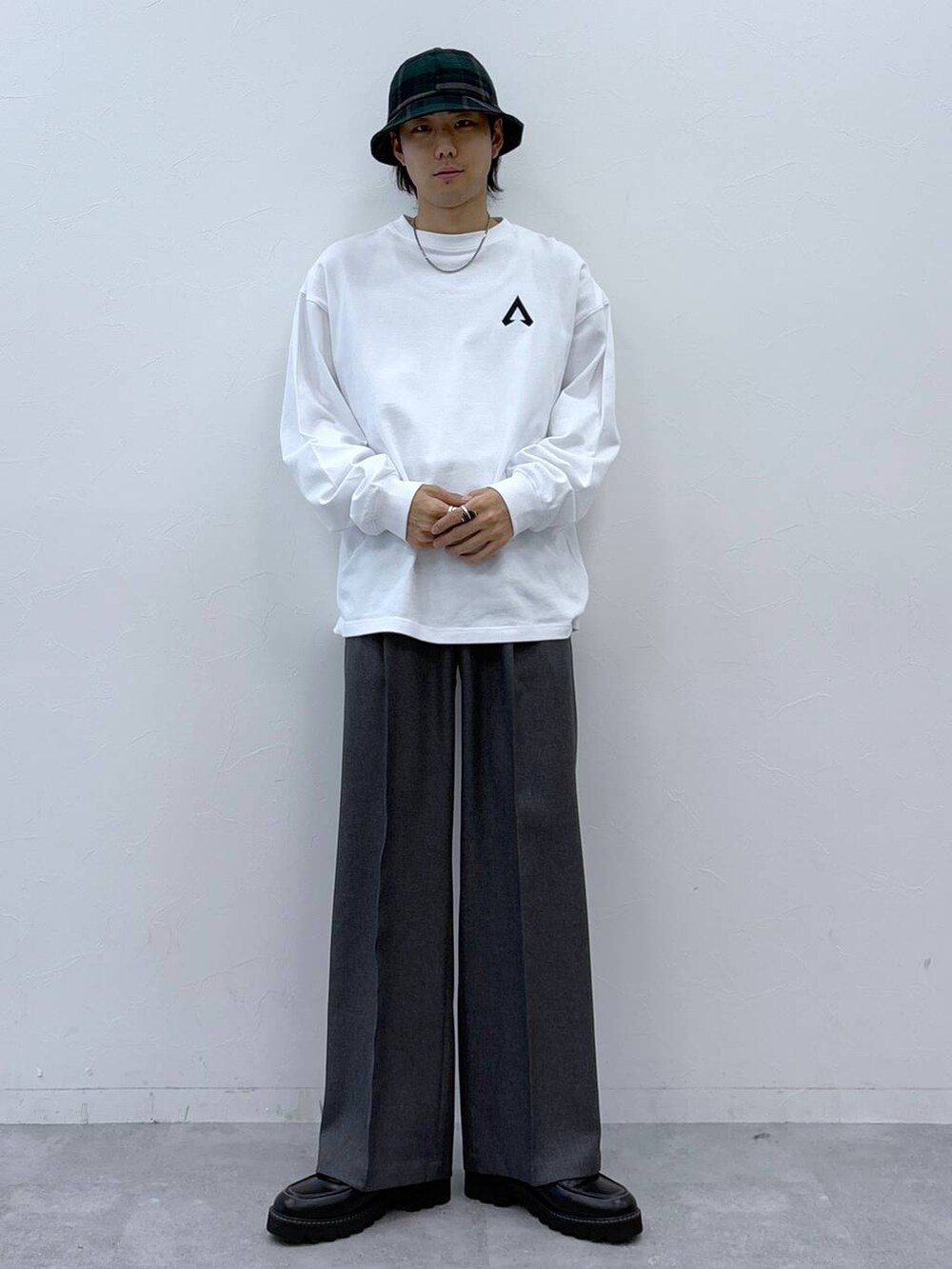 グレー系のスラックス、ブラック系のドレスシューズ、ホワイト系のTシャツ/カットソーを着用したメンズの冬コーディネートの4枚目の写真