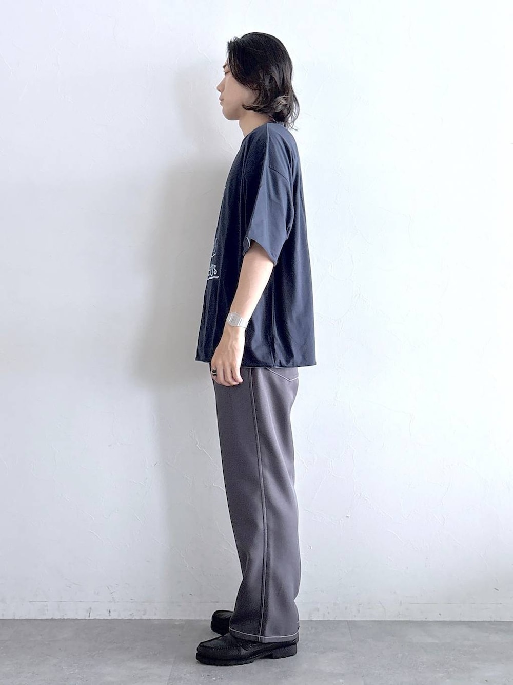 グレー系のスラックス、ブルー系のTシャツ/カットソーを着用したメンズの夏コーディネートの4枚目の写真