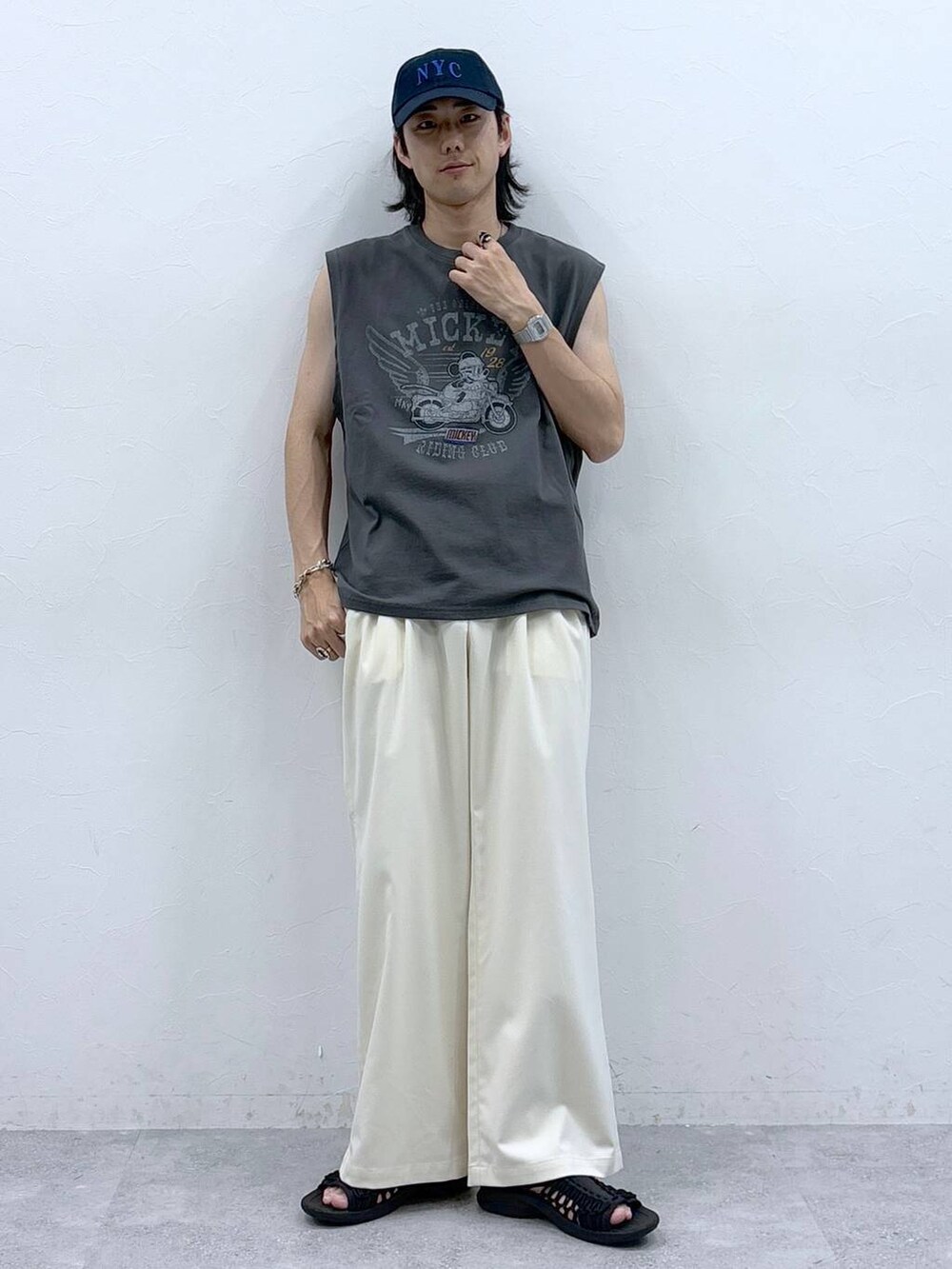 ホワイト系のスラックス、ブラック系のタンクトップを着用したメンズの春コーディネートの2枚目の写真