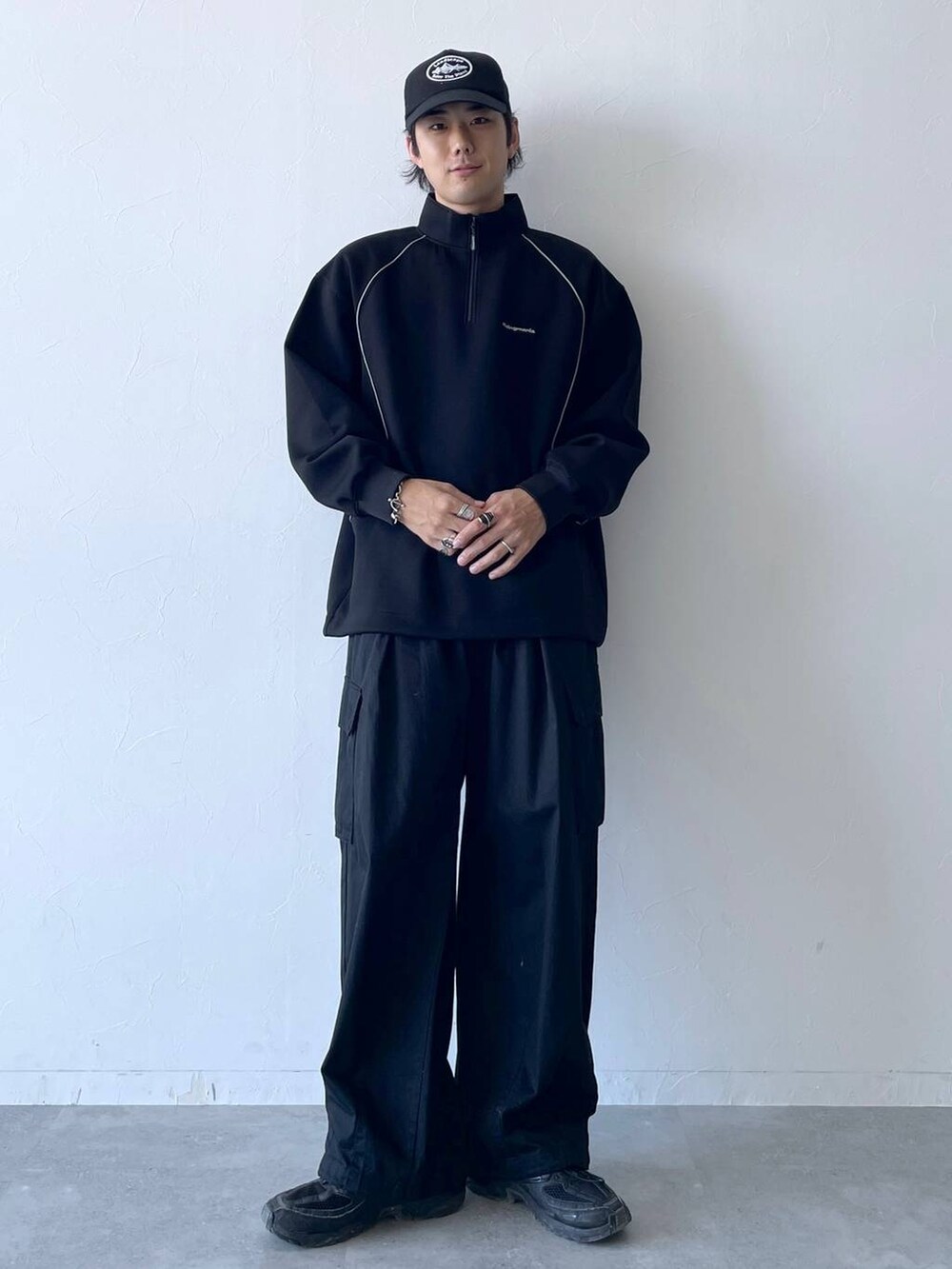 ブラック系のカーゴパンツ、ブラック系のスウェット、ブラック系のキャップを着用したメンズの秋コーディネートの2枚目の写真