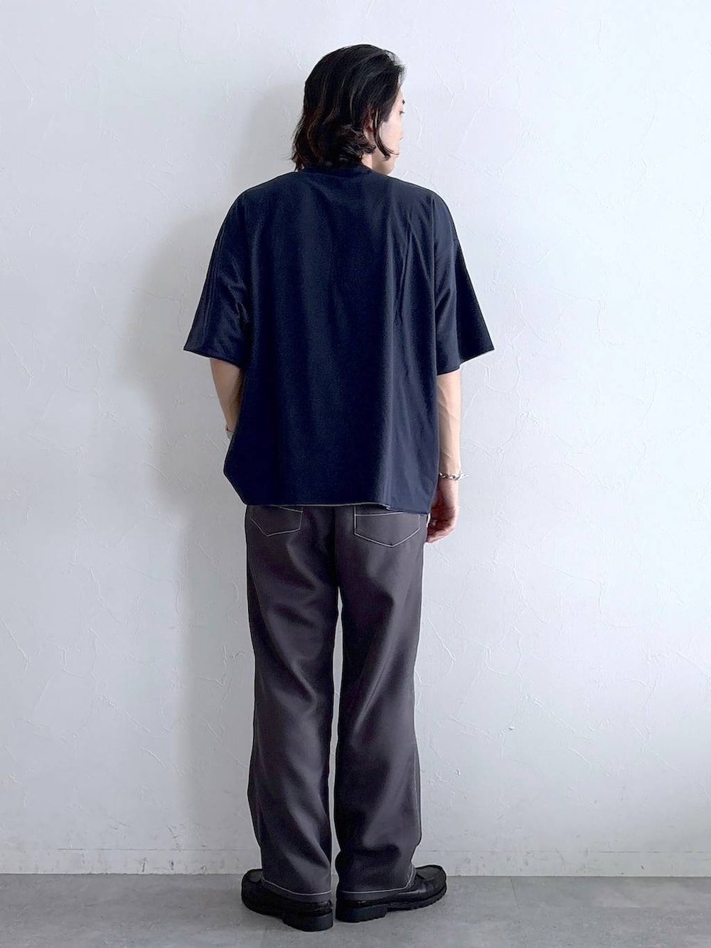 グレー系のスラックス、ブルー系のTシャツ/カットソーを着用したメンズの夏コーディネートの5枚目の写真