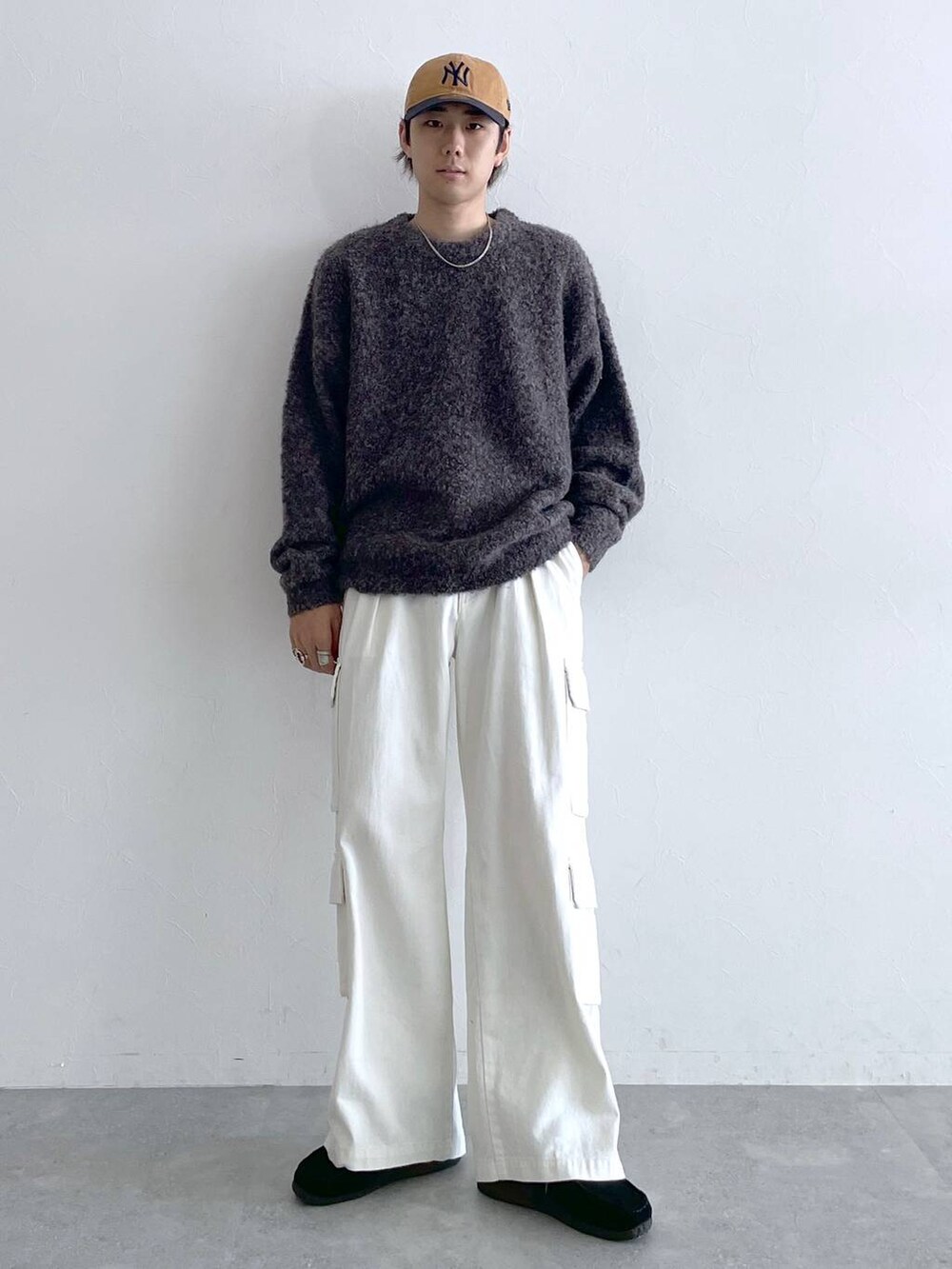 ホワイト系のデニムパンツ、ブルー系のキャップ、シルバー系のネックレスを着用したメンズの夏コーディネートの3枚目の写真