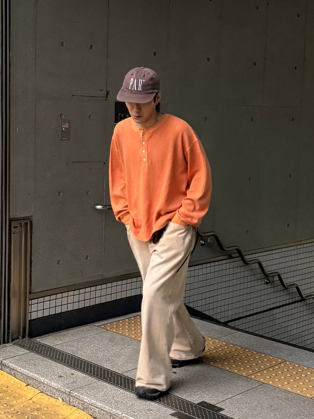 オレンジ系のTシャツ/カットソーを着用したメンズの春コーディネートの4枚目の写真