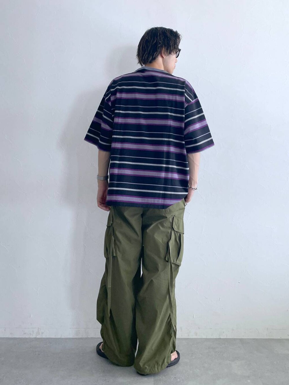 ブラック系のサンダル、ブラック系のTシャツ/カットソー、グリーン系のカーゴパンツを着用したメンズの夏コーディネートの5枚目の写真