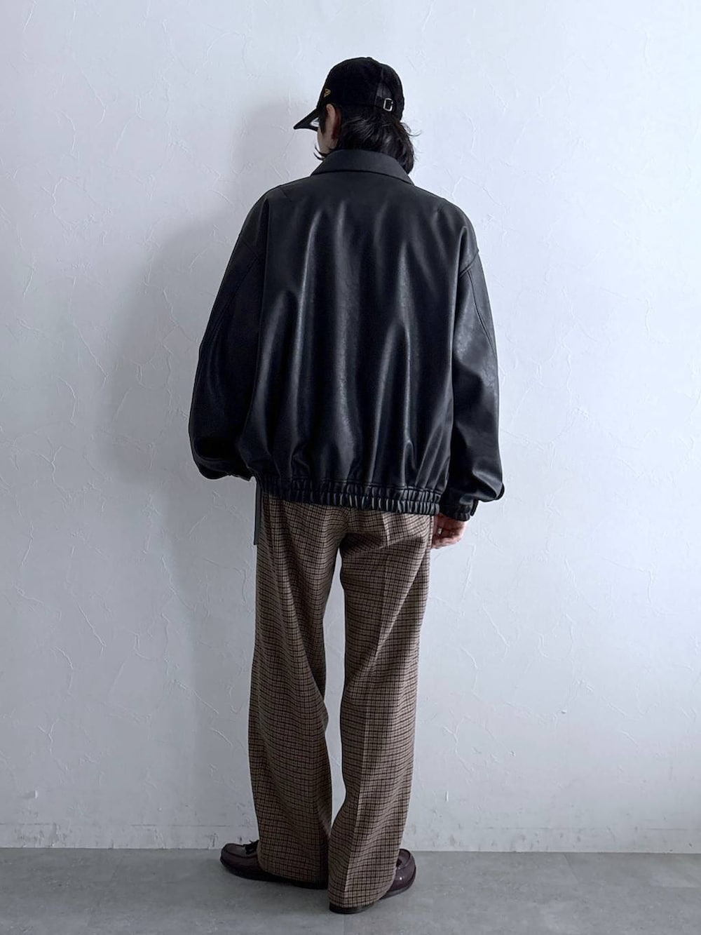 ブラック系のブルゾン、グレー系のTシャツ/カットソー、その他のスラックスを着用したメンズの秋コーディネートの6枚目の写真