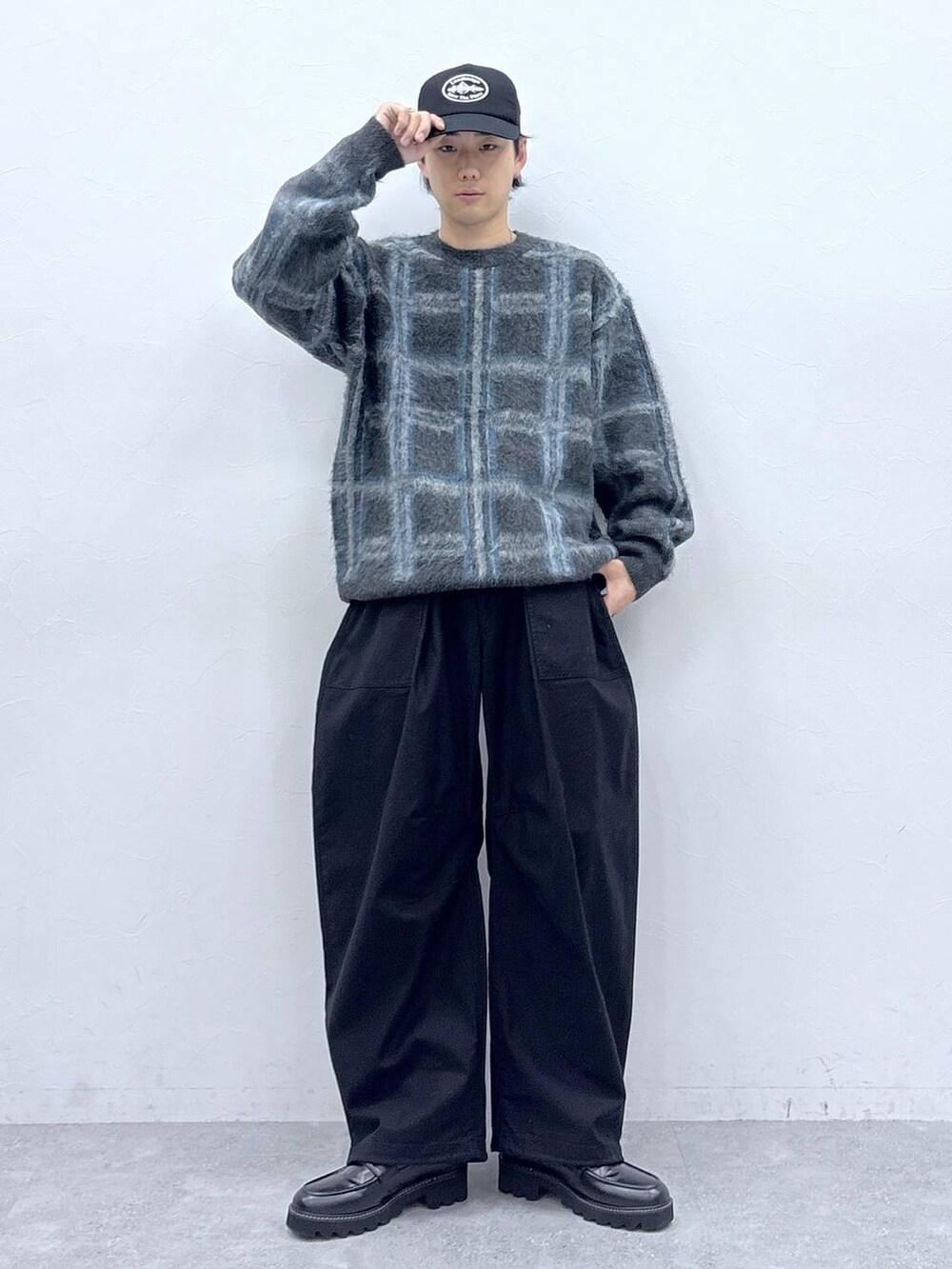 ブラック系のドレスシューズ、グレー系のニット/セーター、ブラック系のキャップを着用したメンズの秋コーディネートの3枚目の写真