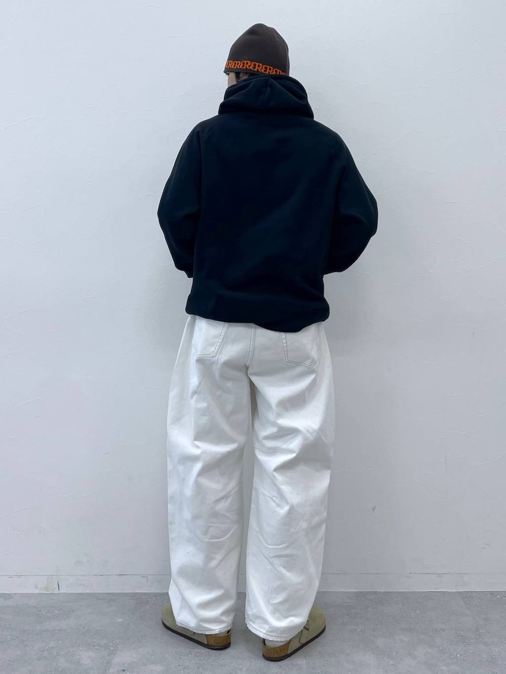ブラック系のパーカー、ホワイト系のデニムパンツ、ブラウン系のニットキャップ/ビーニーを着用したメンズの秋コーディネートの6枚目の写真