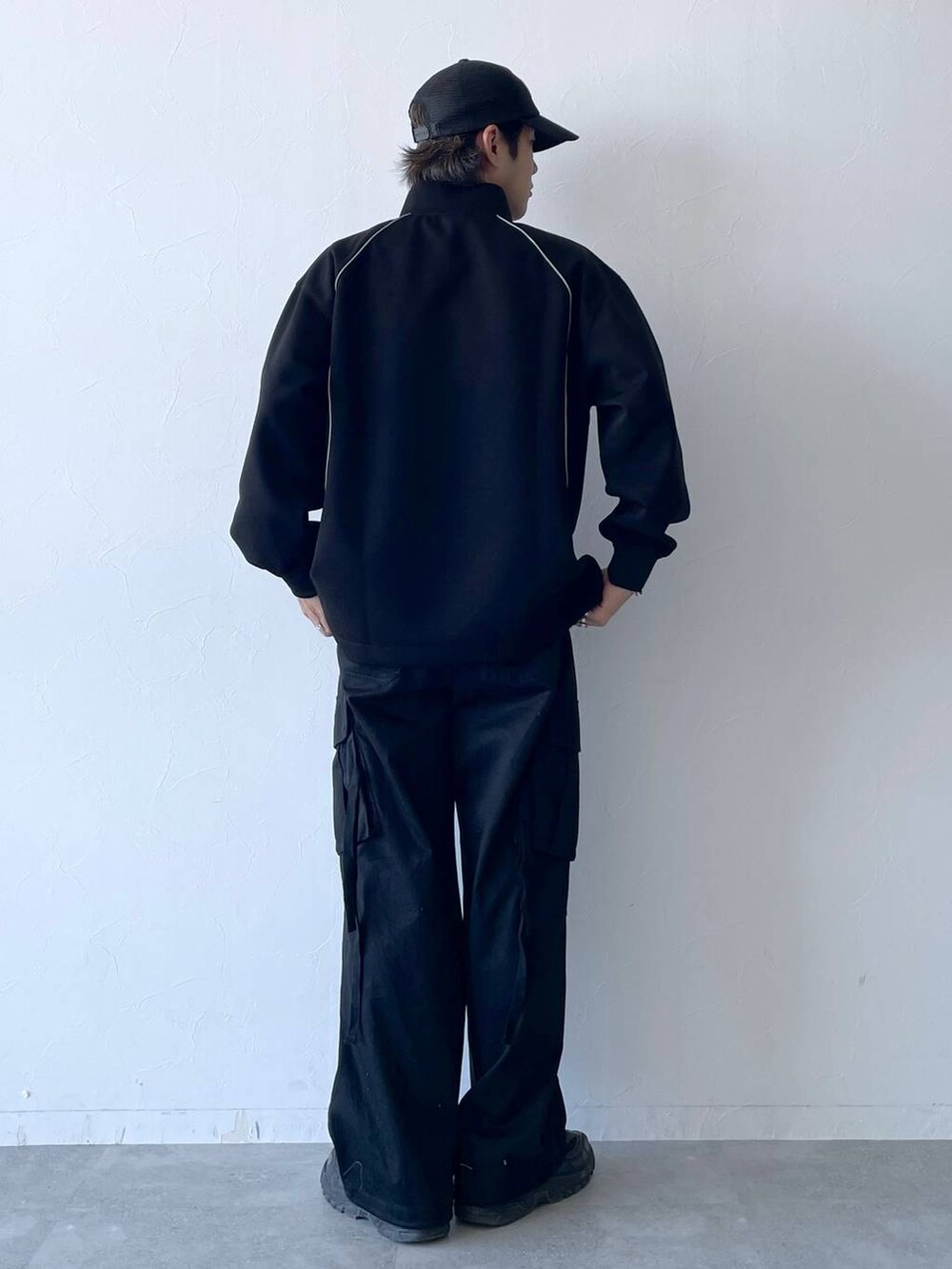 ブラック系のカーゴパンツ、ブラック系のスウェット、ブラック系のキャップを着用したメンズの秋コーディネートの4枚目の写真
