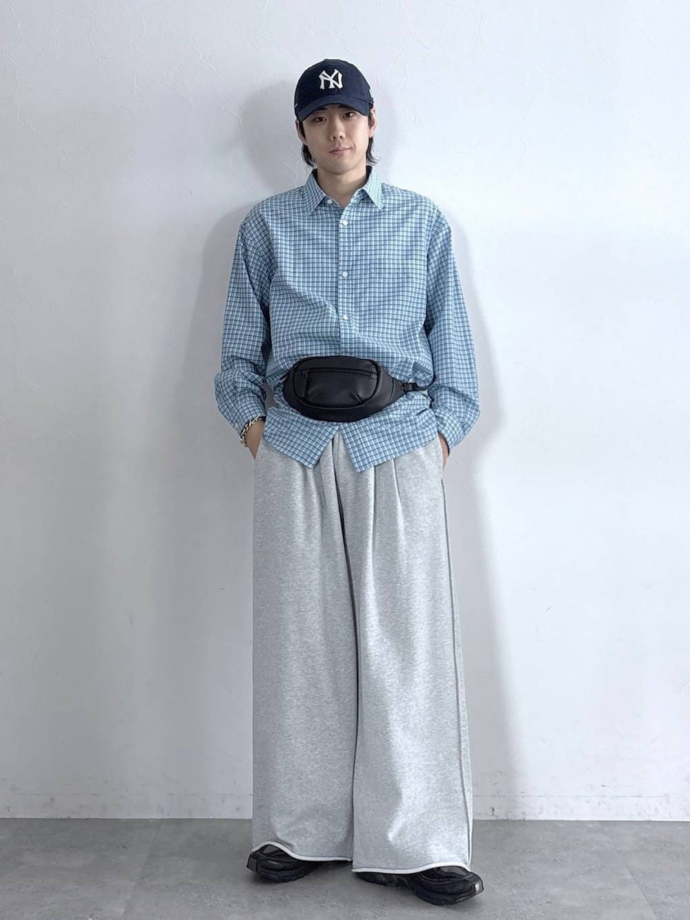 ブルー系のシャツ/ブラウス、ブラック系のボディバッグ/ウエストポーチ、グレー系のスウェットパンツを着用したメンズの春コーディネートの2枚目の写真