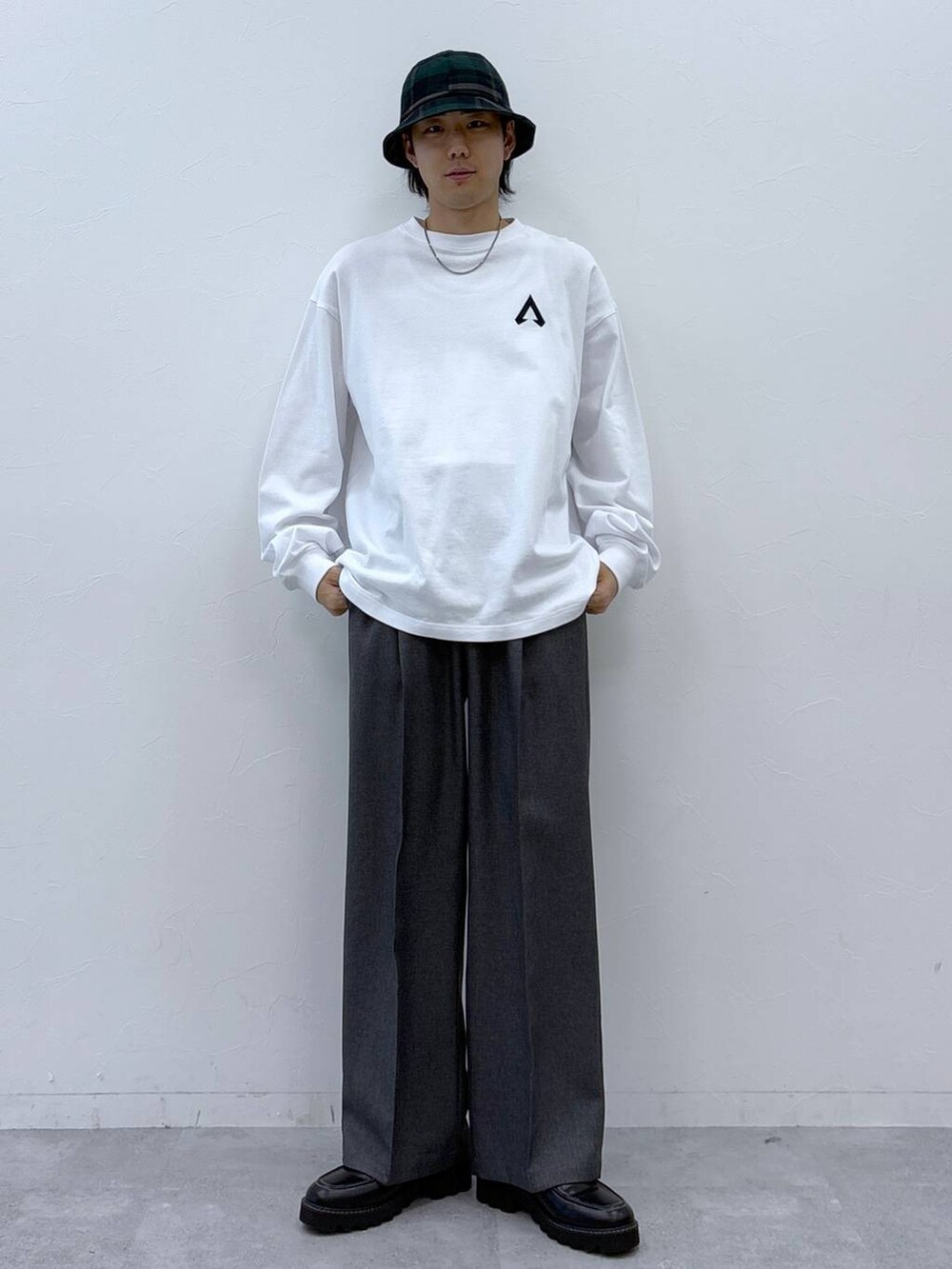 グレー系のスラックス、ブラック系のドレスシューズ、ホワイト系のTシャツ/カットソーを着用したメンズの冬コーディネートの6枚目の写真