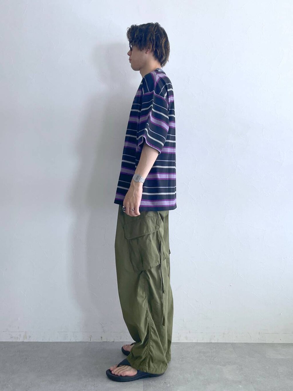 ブラック系のサンダル、ブラック系のTシャツ/カットソー、グリーン系のカーゴパンツを着用したメンズの夏コーディネートの4枚目の写真