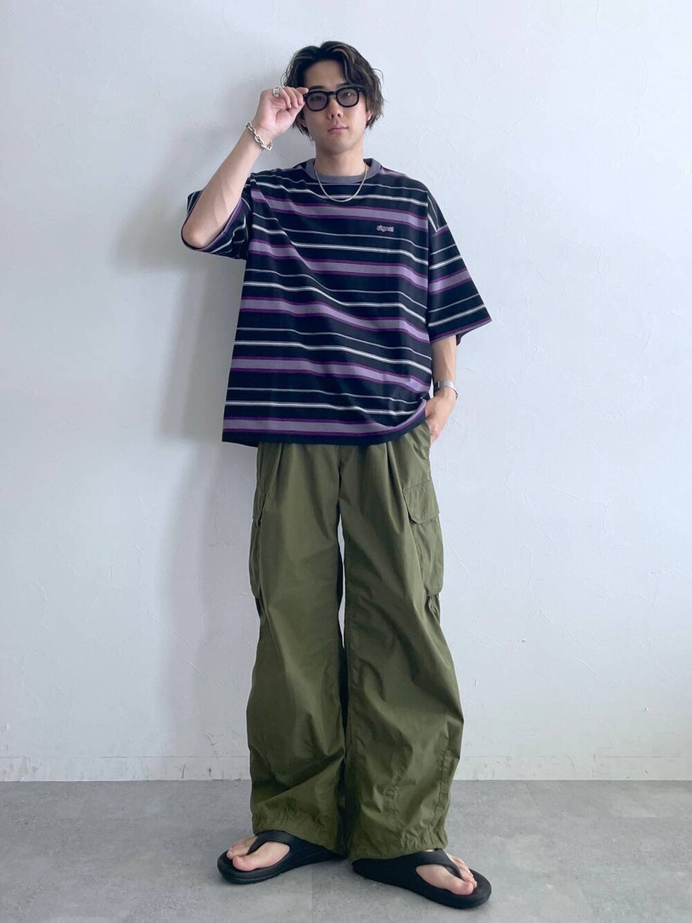 ブラック系のサンダル、ブラック系のTシャツ/カットソー、グリーン系のカーゴパンツを着用したメンズの夏コーディネートの2枚目の写真