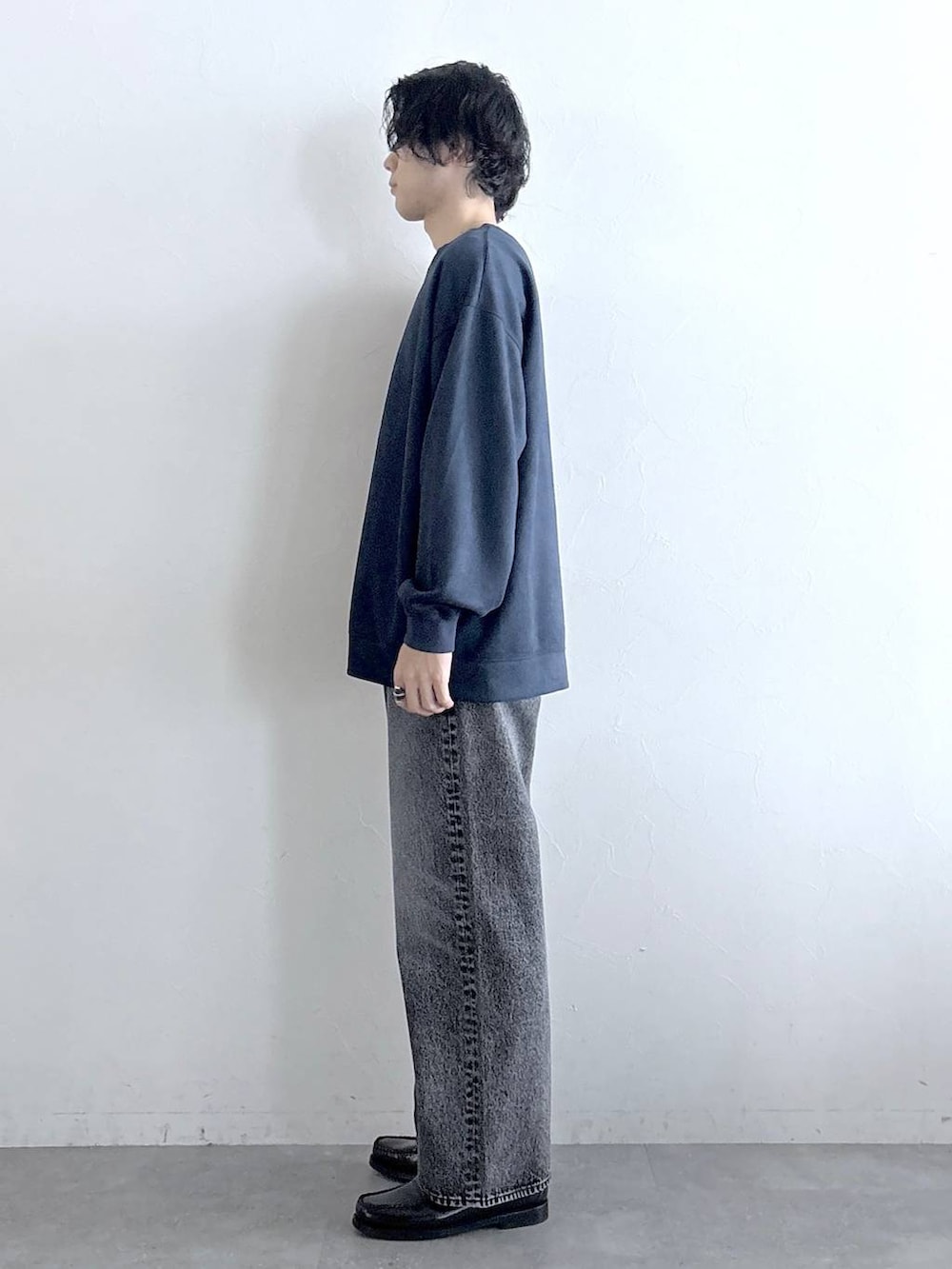 ブルー系のスウェット、グレー系のデニムパンツ、その他のネックレスを着用したメンズの冬コーディネートの6枚目の写真
