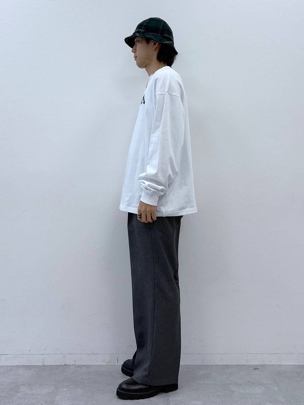 グレー系のスラックス、ブラック系のドレスシューズ、ホワイト系のTシャツ/カットソーを着用したメンズの冬コーディネートの7枚目の写真