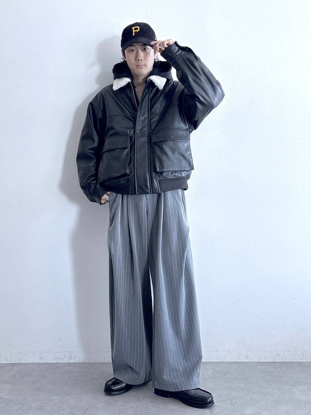 ブラック系のブルゾン、グレー系のスラックス、グレー系のパーカーを着用したメンズの冬コーディネートの2枚目の写真