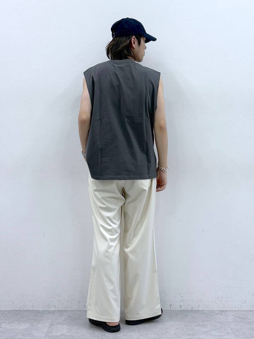 ホワイト系のスラックス、ブラック系のタンクトップを着用したメンズの春コーディネートの7枚目の写真