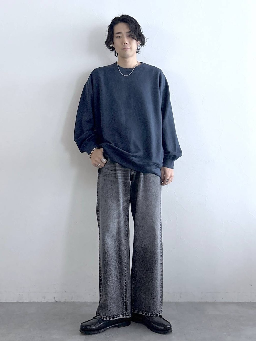 ブルー系のスウェット、グレー系のデニムパンツ、その他のネックレスを着用したメンズの冬コーディネートの2枚目の写真
