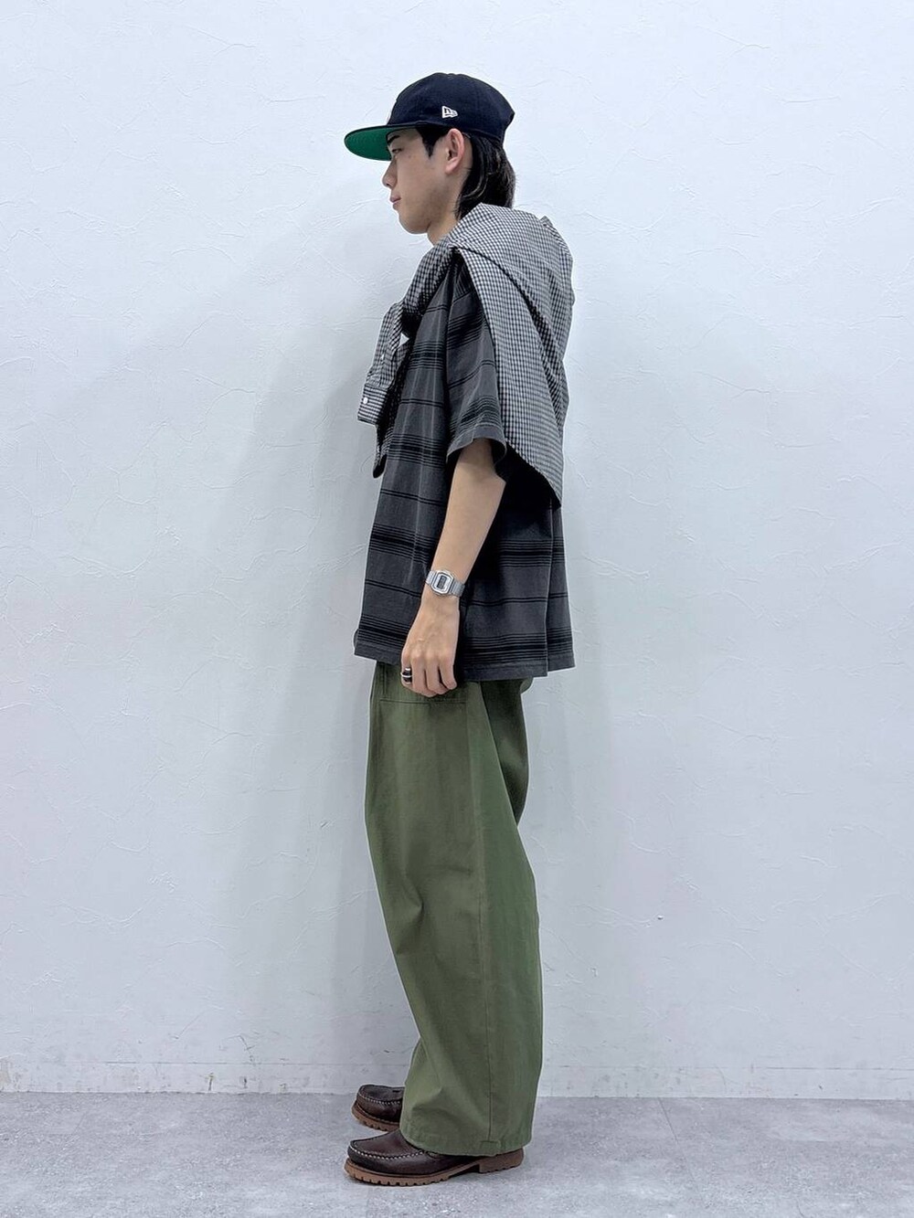 グリーン系のカーゴパンツ、ブラック系のシャツ/ブラウス、グレー系のTシャツ/カットソーを着用したメンズの春コーディネートの5枚目の写真