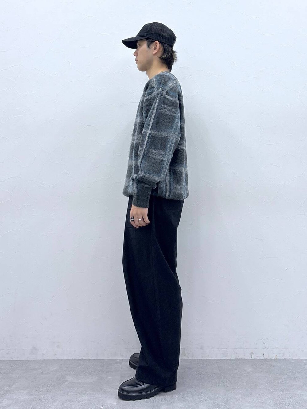 ブラック系のドレスシューズ、グレー系のニット/セーター、ブラック系のキャップを着用したメンズの秋コーディネートの4枚目の写真