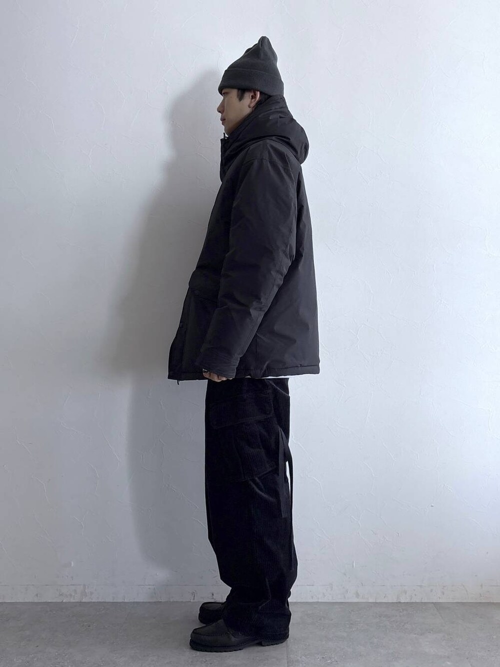 ブラック系のダウンジャケット/コート、ブラック系のカーゴパンツ、その他のネックレスを着用したメンズの冬コーディネートの6枚目の写真