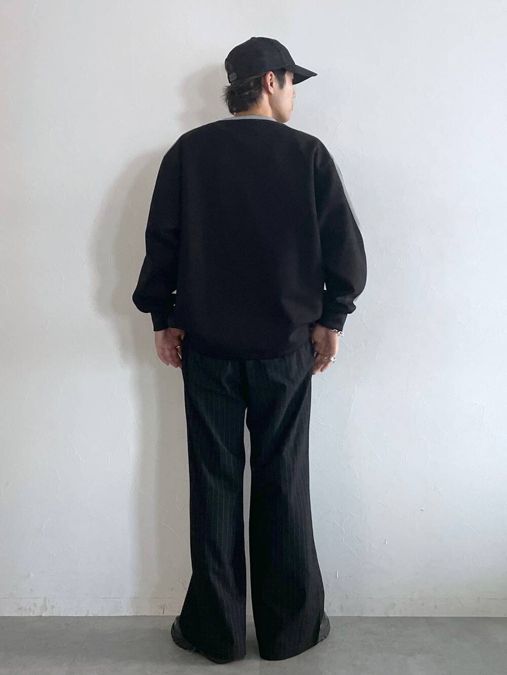 ブラック系のスラックス、ブラック系のスウェット、シルバー系のネックレスを着用したメンズの秋コーディネートの5枚目の写真