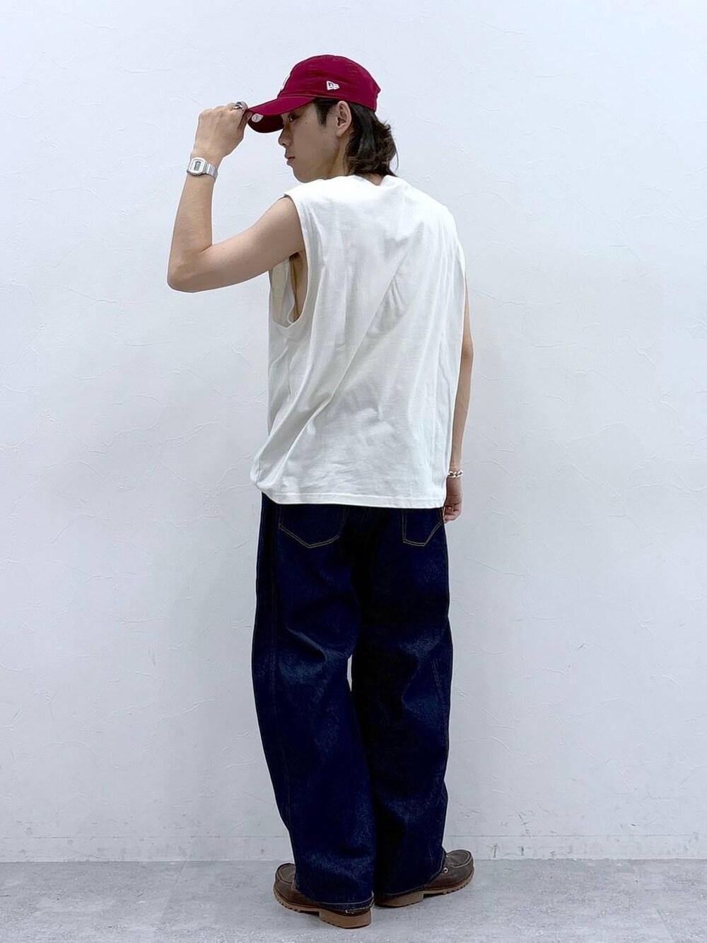 ホワイト系のタンクトップ、ブルー系のデニムパンツを着用したメンズの春コーディネートの3枚目の写真