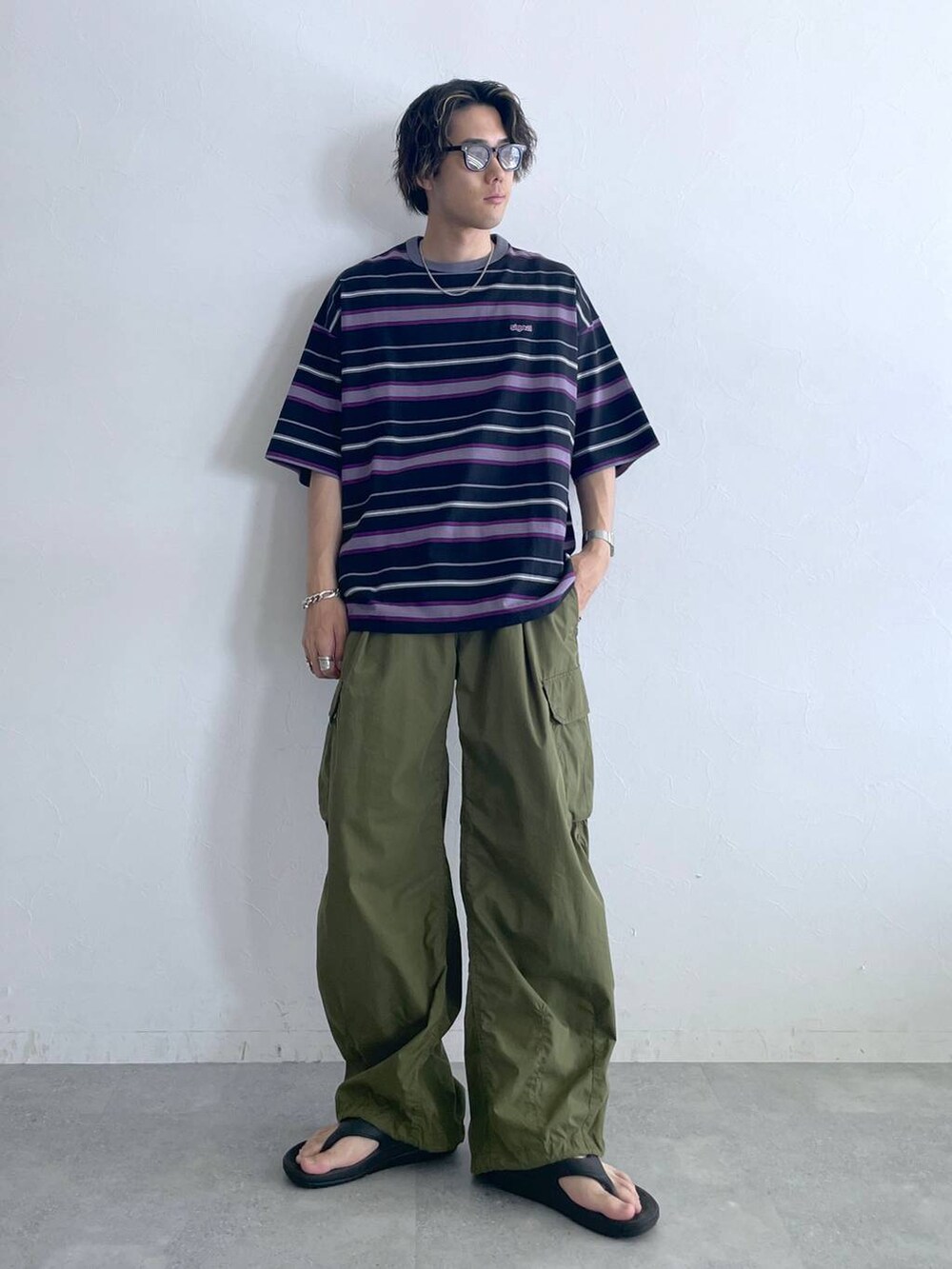 ブラック系のサンダル、ブラック系のTシャツ/カットソー、グリーン系のカーゴパンツを着用したメンズの夏コーディネートの3枚目の写真