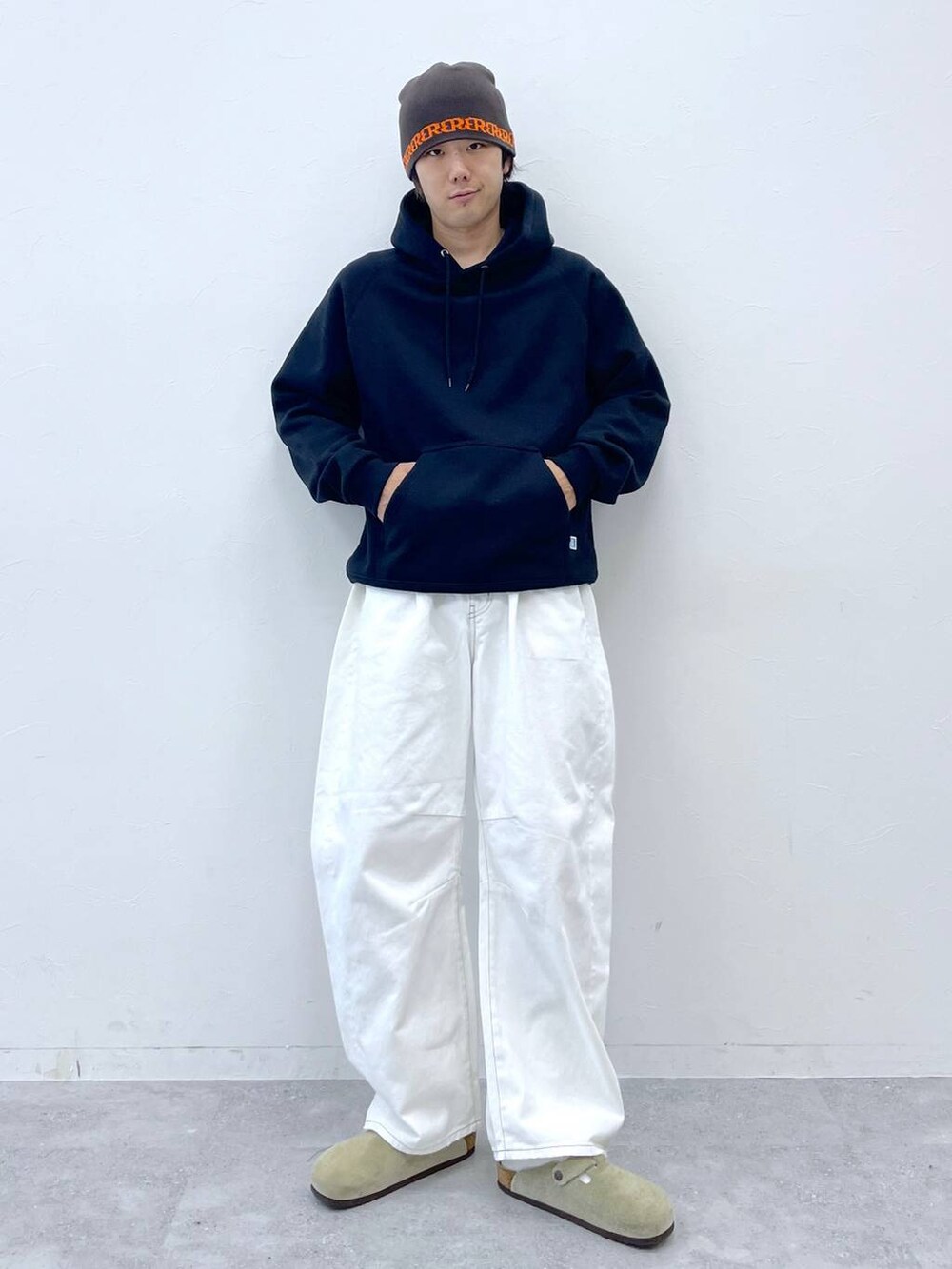ブラック系のパーカー、ホワイト系のデニムパンツ、ブラウン系のニットキャップ/ビーニーを着用したメンズの秋コーディネートの2枚目の写真