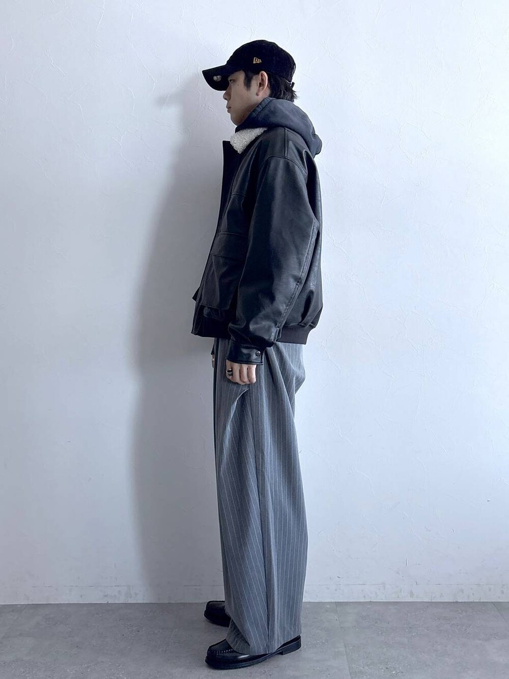 ブラック系のブルゾン、グレー系のスラックス、グレー系のパーカーを着用したメンズの冬コーディネートの4枚目の写真