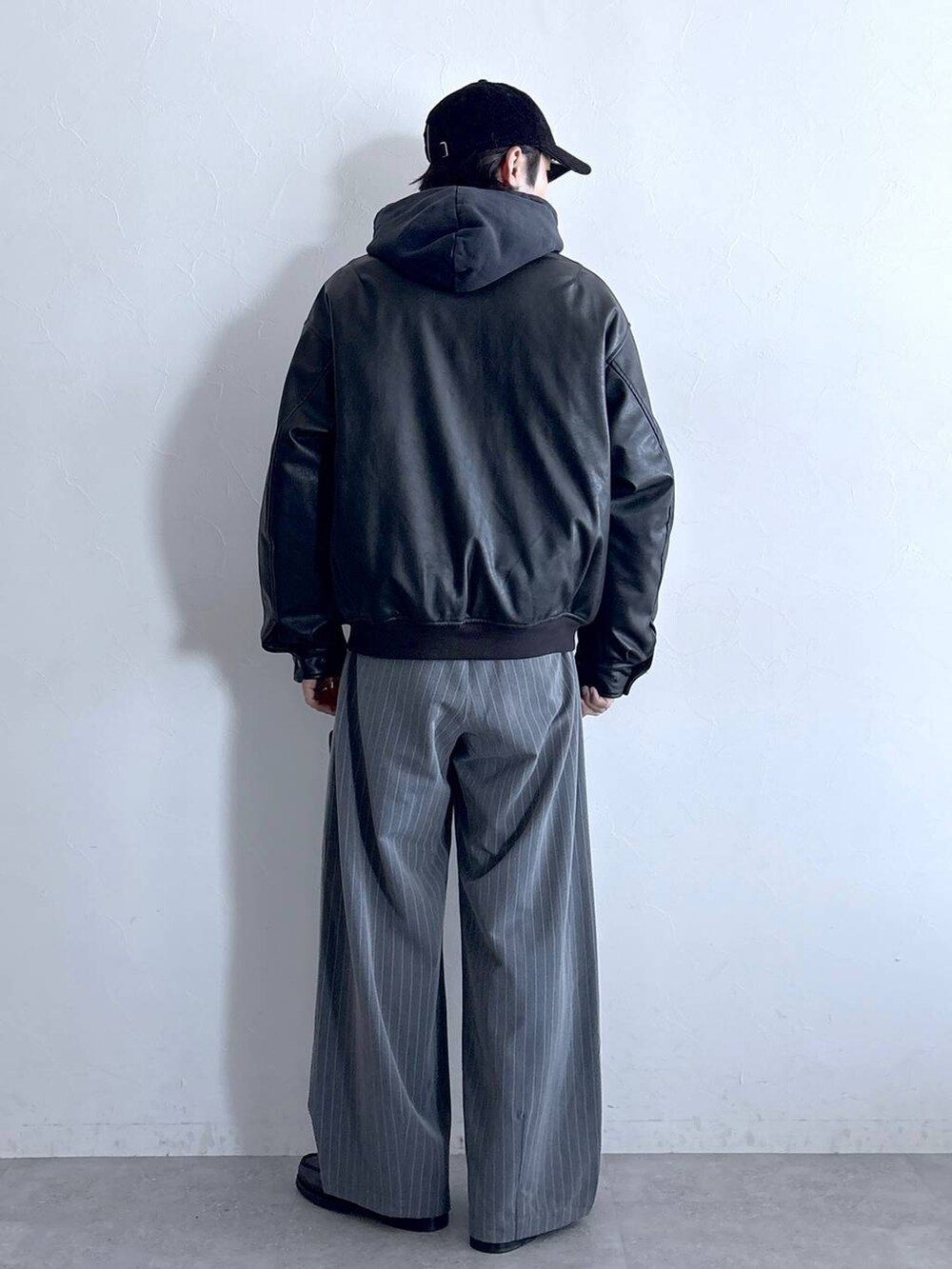 ブラック系のブルゾン、グレー系のスラックス、グレー系のパーカーを着用したメンズの冬コーディネートの5枚目の写真