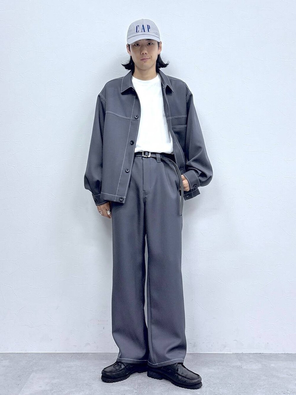 グレー系のブルゾン、グレー系のスラックス、ホワイト系のTシャツ/カットソーを着用したメンズの秋コーディネートの4枚目の写真